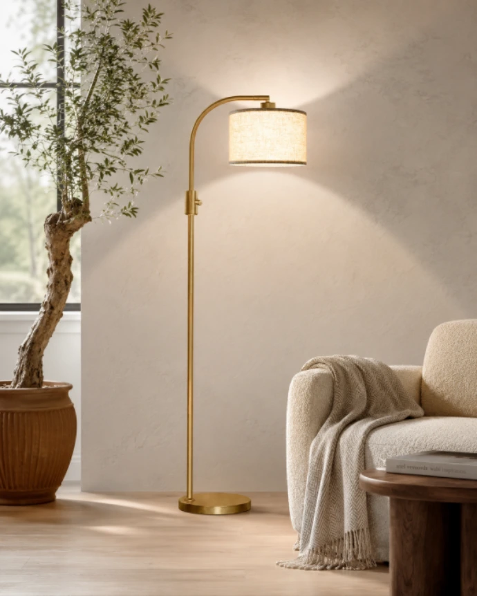 Modern gold arc floor lamp arching over a cozy living room seating area.